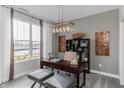 Well-lit home office with a modern light fixture and large window overlooking the front yard at 9387 Abner St, McCordsville, IN 46055