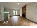 Living room with a brick fireplace, a large window, and stairs at 9560 Bay Vista E Dr, Indianapolis, IN 46250