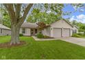 Charming single-story home featuring a manicured lawn, two-car garage, and inviting curb appeal at 975 Atir Ln, Greenfield, IN 46140