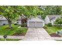 Inviting single-story home with a well-maintained lawn, a two-car garage and a welcoming front entrance at 975 Atir Ln, Greenfield, IN 46140