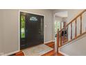 Open foyer featuring hardwood floors, staircase, and front door with decorative glass at 10501 Greenway Dr, Fishers, IN 46037