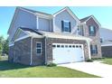 Spacious two-car garage with a brick facade and vinyl siding on a well-maintained two-story home at 1056 Bent Branch Ln, Greenwood, IN 46143