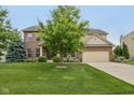 Two-story brick and siding home boasts an attached garage, lush lawn, and mature trees at 11844 Pine Meadow Cir, Fishers, IN 46037