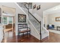 Bright foyer featuring hardwood floors, staircase, a decorative mirror, and a bench seat at 11844 Pine Meadow Cir, Fishers, IN 46037