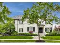 Beautifully landscaped home featuring a lush lawn, mature trees, and a timeless white exterior with black shutters at 12437 Meeting House Rd, Carmel, IN 46032