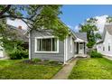 Inviting gray home with freshly cut grass and a landscaped flowerbed enhancing its charm at 1418 Olive St, Indianapolis, IN 46203