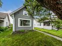 Gray home with green grass and a beautiful tree creating a peaceful outdoor setting at 1418 Olive St, Indianapolis, IN 46203