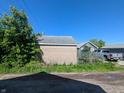 View of the detached garage exterior, showing brick wall and back of house at 1433 N Denny St, Indianapolis, IN 46201