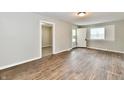 Inviting living room with wood-look floors, neutral walls, and an open doorway to another room at 1730 N Graham Ave, Indianapolis, IN 46218