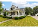 A charming home with white trim and a well-manicured lawn sits on a quiet street at 201 N 11Th St, Elwood, IN 46036