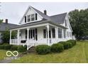 Inviting home features a covered porch, mature landscaping, and classic architecture at 201 N 11Th St, Elwood, IN 46036