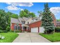 Charming brick home boasts a spacious driveway, lush landscaping, and an attached two-car garage at 2592 Highmount Ct, Carmel, IN 46033
