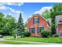 Charming red brick home with black shutters surrounded by a well-maintained lawn and mature trees at 2592 Highmount Ct, Carmel, IN 46033