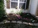 Beautifully landscaped garden bed featuring a variety of colorful flowers and lush greenery adding curb appeal at 2628 Newaygo Dr, Indianapolis, IN 46217