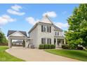 Two-story home boasting a portico, stone accents, manicured lawn, and mature trees at 2898 Violet W Ct, Columbus, IN 47201