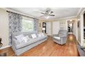 Inviting living room features wood floors, a comfortable gray sofa, recliner and plenty of natural light at 318 S Routiers Ave, Indianapolis, IN 46219