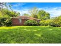 Charming brick home surrounded by lush greenery and a well-manicured lawn at 3215 E Edgewood Ave, Indianapolis, IN 46227