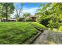 Charming single-story home with a grassy front yard and concrete stairs leading to the driveway at 3215 E Edgewood Ave, Indianapolis, IN 46227