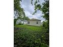 View of the home's backyard, surrounded by lush greenery and mature trees for added privacy at 3305 E 30Th St, Indianapolis, IN 46218