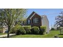 A two-story home with a combination of siding and brick, a well-kept lawn, and green bushes at 409 Spring Green Pl, Indianapolis, IN 46229