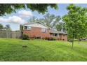 Beautiful brick home with a well-kept lawn, complemented by vibrant flower beds and mature trees at 4614 Thornleigh Dr, Indianapolis, IN 46226