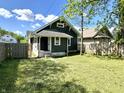 View of a fenced backyard, freshly cut grass, and green leafy trees in the neighborhood at 4814 E New York St, Indianapolis, IN 46201
