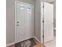 Foyer features wood-look flooring and white door leading to the bathroom at 513 Sun Catcher Dr, Avon, IN 46123