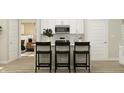 Modern kitchen with white cabinets, stainless steel appliances, and a breakfast bar at 647 Bridgeman Rd, Avon, IN 46123
