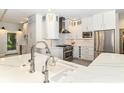 Modern kitchen features white cabinets, marble countertops, stainless steel appliances, and designer backsplash at 7775 N Meridian St, Indianapolis, IN 46260