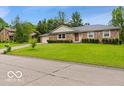 Attractive single-story brick home with a well-manicured lawn and mature trees in a neighborhood setting at 813 Boulder Rd, Indianapolis, IN 46217