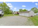 Property featuring a three-car detached garage with a large gravel parking area at 823 W 200 N, Greenfield, IN 46140