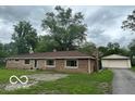 Charming brick home featuring a well-maintained lawn and a detached two car garage at 907 Monroe St, Indianapolis, IN 46229