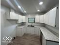 Functional kitchen featuring white cabinets, laminate countertops, and recessed lighting at 907 Monroe St, Indianapolis, IN 46229