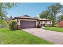 Single-story home featuring an attached garage, landscaped front yard, and charming curb appeal at 976 Santa Maria Dr, Greenwood, IN 46143