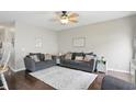 Comfortable living room with neutral walls, ceiling fan, dark wood floors and plush seating at 9771 Blue Violet Dr, Noblesville, IN 46060