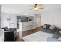 Open-concept living space with a breakfast bar, gray cabinets, and stainless steel appliances at 9771 Blue Violet Dr, Noblesville, IN 46060