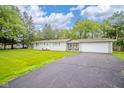 Charming single-story home with a large asphalt driveway leading to an attached two car garage at 10097 N Balfer E Dr, Fortville, IN 46040