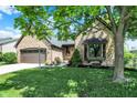 Beautiful brick home with well-maintained lawn, mature trees, and attractive landscaping at 10560 Lighthouse Way, Indianapolis, IN 46256