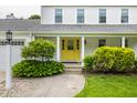 Inviting front entrance features a bright yellow door, manicured landscaping, and a well-lit walkway at 10833 Marquette Rd, Zionsville, IN 46077
