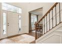 Bright foyer featuring a beautiful front door, wood floors, staircase, and view into dining space at 11552 Buckskin Dr, Zionsville, IN 46077