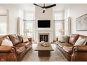 Bright and airy living room featuring high ceilings, fireplace, and comfortable leather couches at 11552 Buckskin Dr, Zionsville, IN 46077
