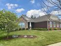 Attractive home with stone and brick accents, manicured lawn and mature trees at 11700 Harvest Moon Dr, Noblesville, IN 46060