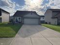 Single Gathering home featuring a two-car garage, tidy lawn and patriotic decorations at 1420 Wigwam Ln, Martinsville, IN 46151