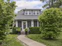 Inviting home with a manicured lawn, pathway, and blossoming trees framing the entrance at 150 E 46Th St, Indianapolis, IN 46205