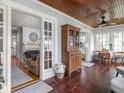 Bright sunroom featuring tiled floors, a wood ceiling, a vintage cabinet, and dining set at 150 E 46Th St, Indianapolis, IN 46205