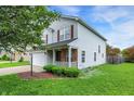 Well-kept two-story home with a two-car garage, a cozy front porch, and vibrant green lawn at 15264 Ten Point Dr, Noblesville, IN 46060