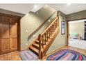 Basement staircase with hardwood flooring and natural wood banister leading to the lower level at 15264 Ten Point Dr, Noblesville, IN 46060