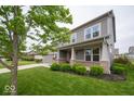 Gray two-story house featuring a brick front porch and a perfectly manicured green lawn at 15675 Myland Dr, Noblesville, IN 46062