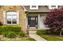 Inviting entryway with a decorative front door, stone accents, and manicured landscaping at 1820 N 1100 E, Sheridan, IN 46069