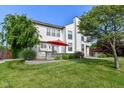 Expansive backyard featuring mature trees, a well-manicured lawn, a stone patio, and a red umbrella at 18967 Mill Grove Dr, Noblesville, IN 46062